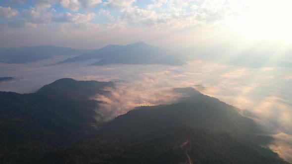 Flying over the clouds during morning sunrise