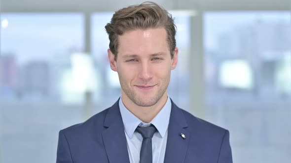Portrait of Attractive Young Businessman Saying Yes By Head Shake