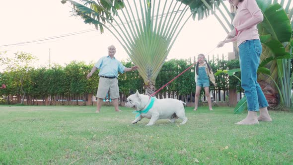 Family Asian parent, Grandfather, and child daughter play soccer together at home