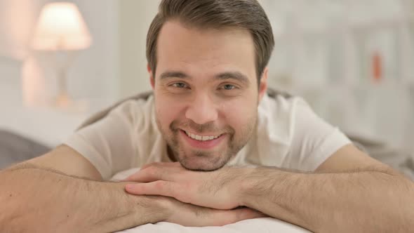 Close Up Young Man Smiling at Camera in Bed