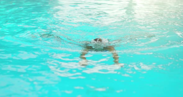 Woman Relaxing in Swimming Pool in Sunny Day Into Water