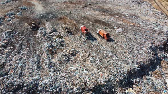 Aerial view of a garbage truck unloads a pile of garbage at a landfill.