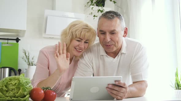 Senior Couple Talking To Family Using Tablet Computer.