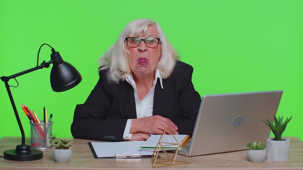 Senior Mature Older Office Businesswoman Working on Laptop Computer Making Funny Face Fooling Around