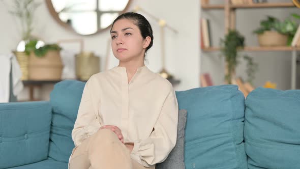 Tired Indian Woman with Neck Pain Sitting on Sofa