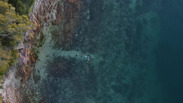 Unique high drone view looking down on a group of scuba getting ready setting up equipment to dive a