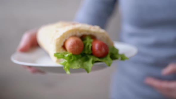 Woman Waiter Brings Plate Juicy American Hot Dog with Sausages and Lettuce Leave