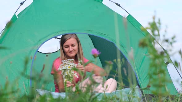 Beautiful Girl Resting in the Mountains She is Sitting Near a Green Tent