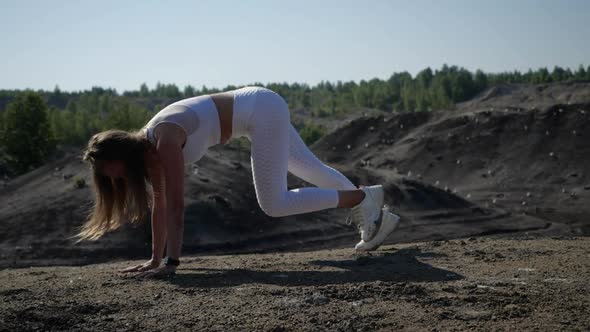 A Young Woman in White Sports Uniform Does Sports Exercises for Her Feet