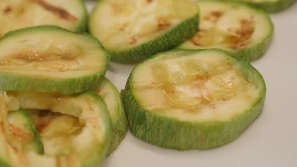 Grilled Pepo cylindrica slices close-up 4K 2160p 30fps UltraHD panning footage - Tasty  zucchini on 