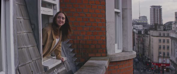 Woman smiling leaning out of window view from outside