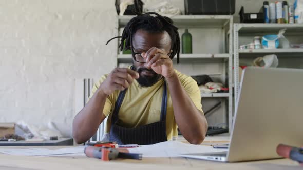 Thoughtful carpenter working at table 4k