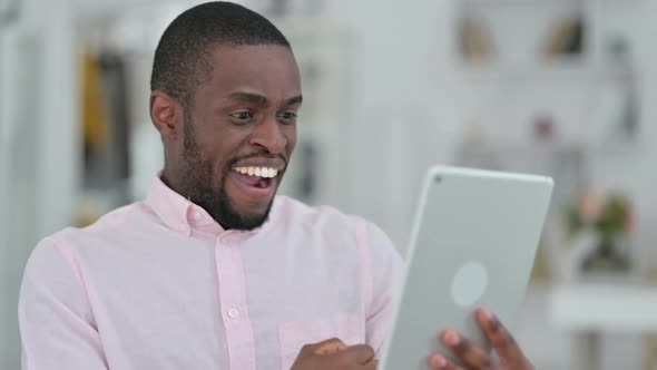 Portrait of African Man Celebrating Success on Tablet