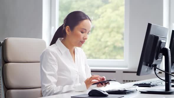 Asian business woman is working at her table in a modern office.