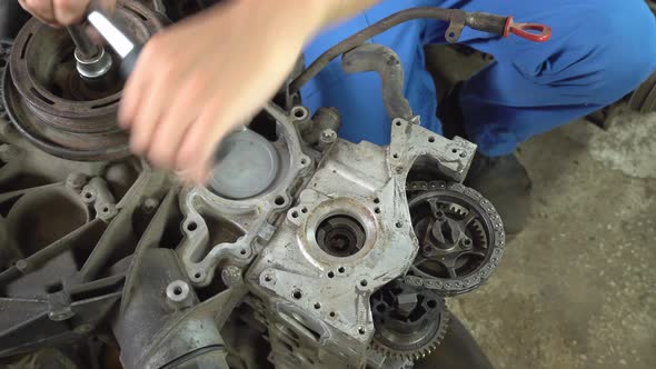 View of disassembled car engine. hands of mechanic repairing engine