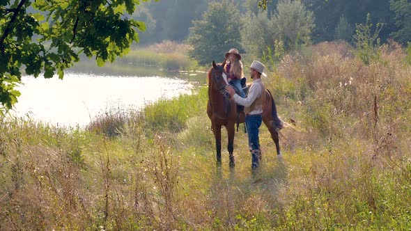 Cowboy and His Daughter on Horseback