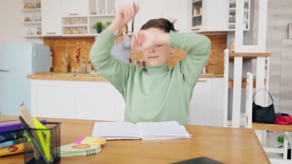 Boy In Kitchen Doing Homework And Chatting with Laptop on the Table