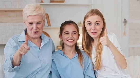 Happy Three Generations Family Daughter Mother Grandmother Sitting on Sofa Looks at Web Camera