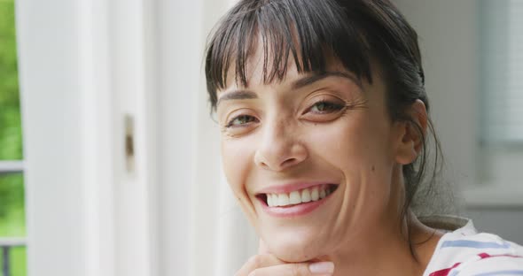 Portrait of happy caucasian woman wearing blouse in living room