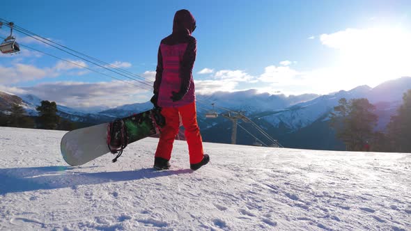 Girl Snowboarder with Snowboard on Mountain Top on Ski Resort. Winter Sports and Winter Vacation