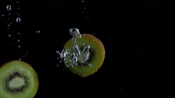 Kiwi Falling into Water Super Slowmotion, Black Background, lots of Air Bubbles, 4k240fps