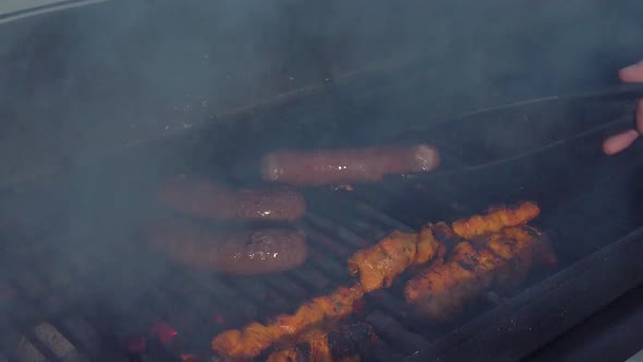 Looking at the Sausages and Chicken Sate getting the heat and smoke of the BBQ. Turning the Sausages