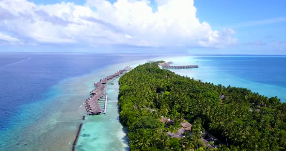 Daytime flying clean view of a paradise sunny white sand beach and aqua blue water background in vibrant