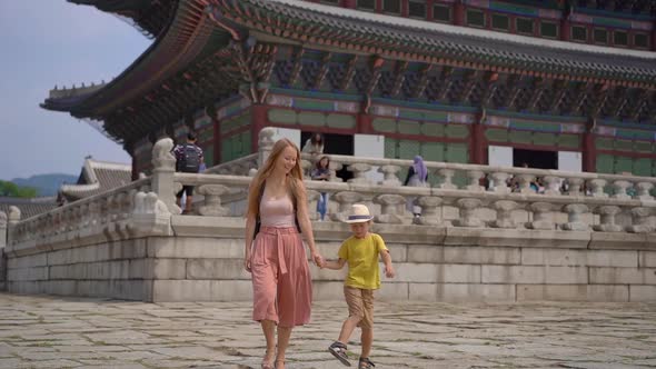 Young Woman and Her Little Son Visit Ancient Palace in Seoul, South Korea. Travel To Korea Concept
