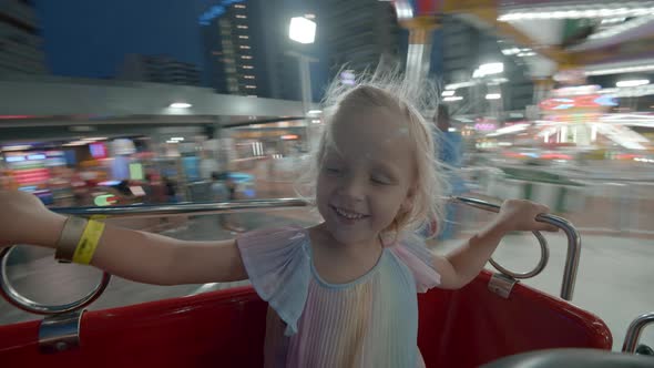 Happy Girl in Merrygoround in the Evening