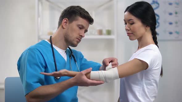 Attentive Therapist Fixing Elbow Elastic Warp Female Patient After Injury Health