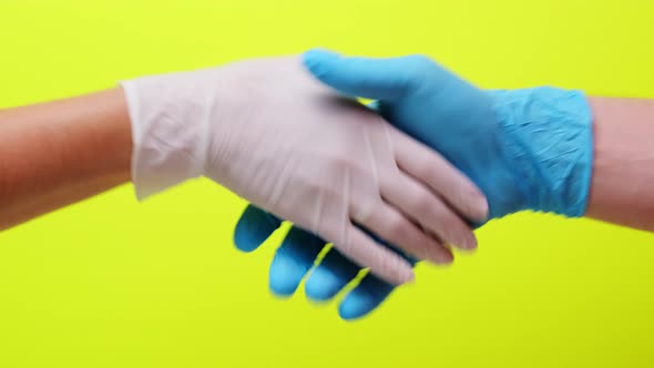 Medical Collaboration and Doctors Hold Hands To Each Other on a Yellow Background