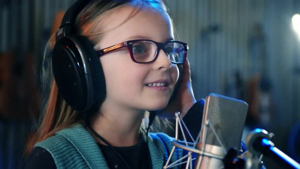 Kid Singing in studio.Little Girl Singing a song.Front View Close Up. Kid Wearing Headphones