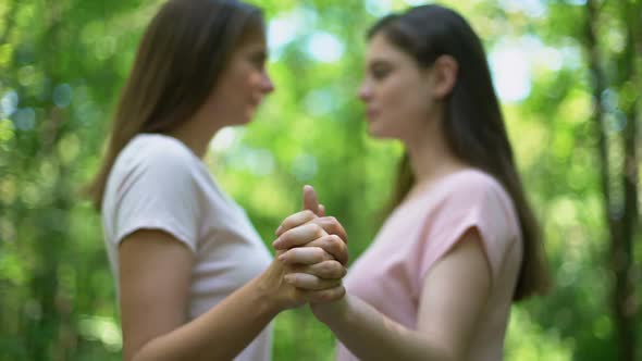 Lesbians Holding Hands Firmly and Kissing, Support Despite Society Condemnation