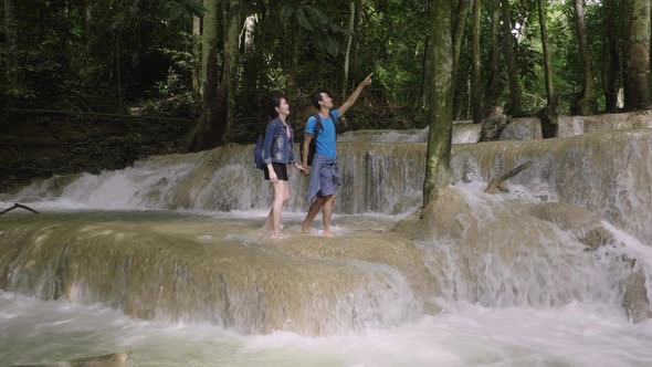 Couple Holding Hand And Walking At Waterfall