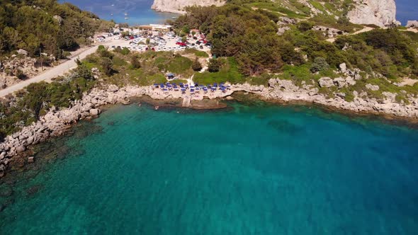 bird's eye view over Anthony Quinn beach on the island of Rhodes with the waiting beach chairs and p