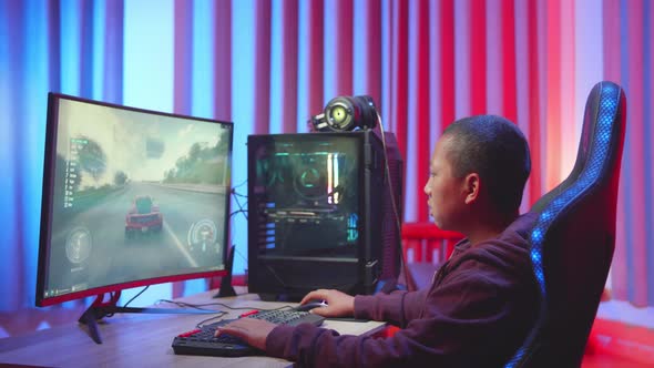 Excited Young Boy Playing Car Race Game On A Computer