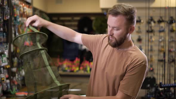 Bearded Man in a Fishing Tackle Shop Getting Ready for a Fishing Trip