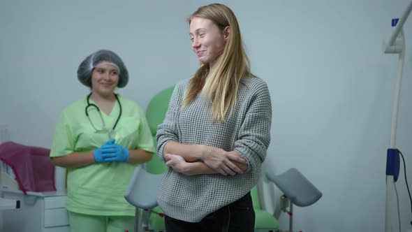 Charming Teenage Girl Looking Back at Gynecologist and Looking at Camera Gesturing Thumb Up Smiling