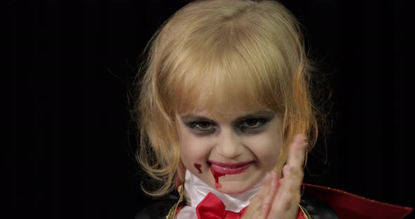 Dracula Child. Girl with Halloween Make-up. Vampire Kid with Blood on Her Face