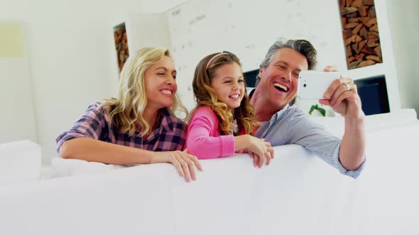 Happy family taking selfie on mobile phone in living room 4k