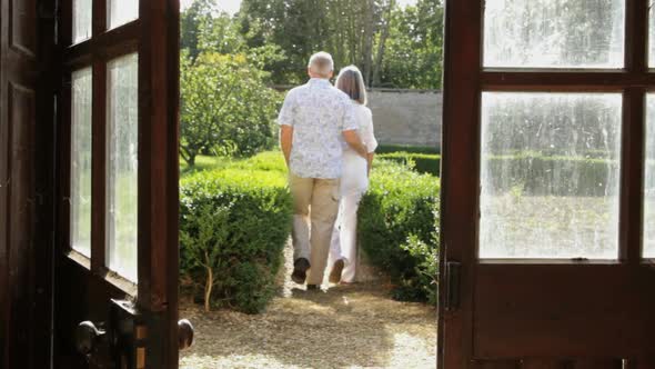 Mature couple walking into the garden