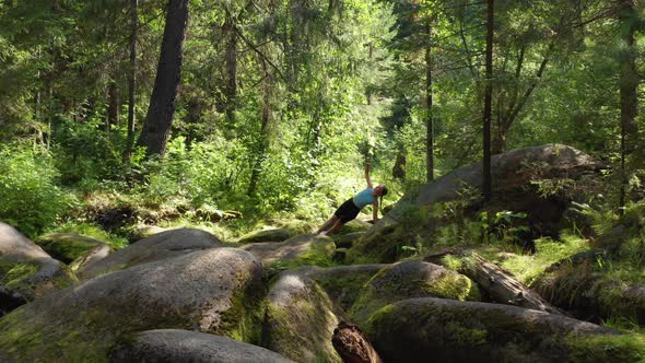 A Girl Practices Balance and Yoga in the Forest