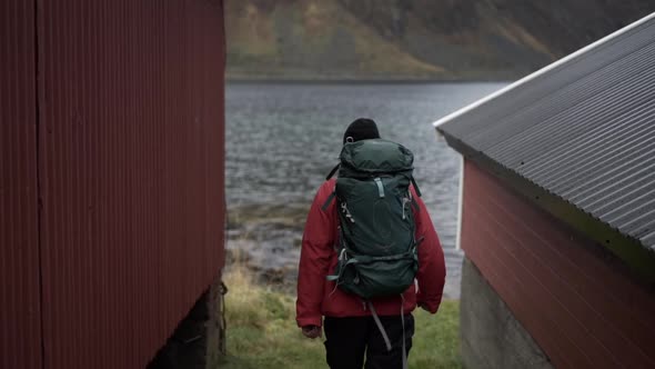 Hiker Walking Between Fisherman's Huts