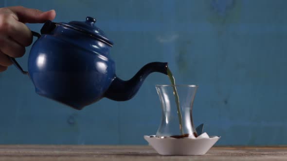 Pouring Tea From a Kettle in a Cup