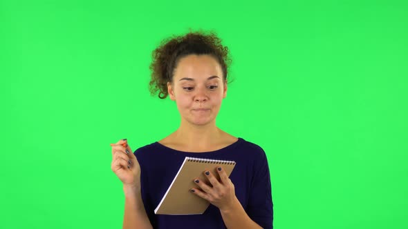 Portrait of Curly Woman with TV Remote in Her Hand, Switching on TV. Green Screen