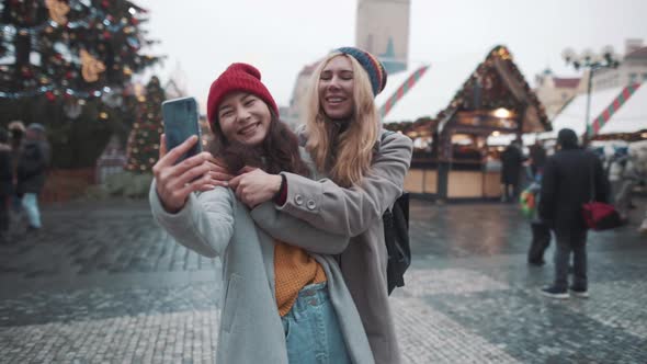 Portrait of Two Girls Making Selfie in Center of Square in European Town