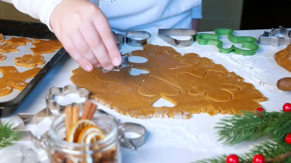 Making gingerbread cookies. Child cuts big star with Christmas mold on table