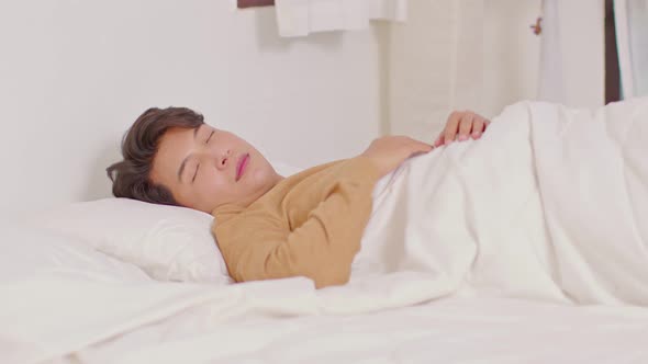 Handsome Attractive Asian man sleep and sweet dream lying on bed in cozy bedroom