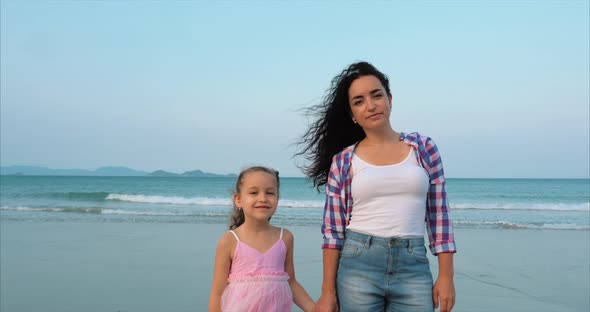 Portrait Clouse Up Mother and Daughter Are Walking Along the Coast. Happy Family Walking on Sea