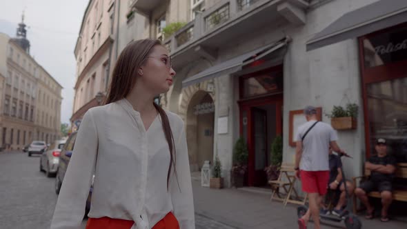 Young Female Traveler is Walking on Old Street of City in Daytime